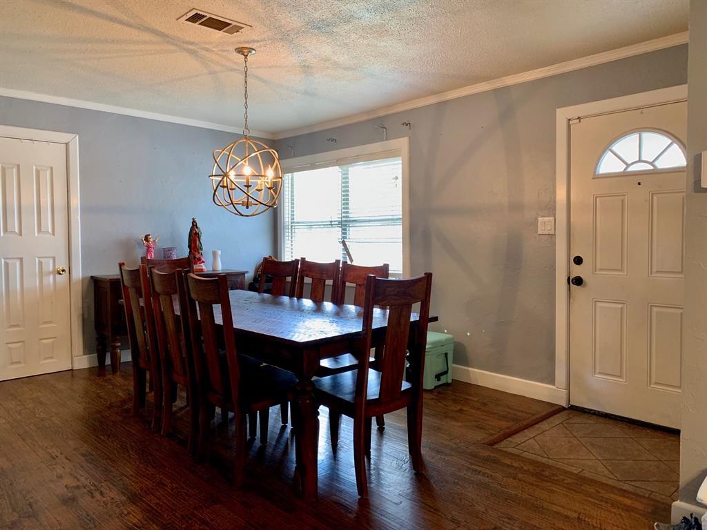 A dining room with a table and chairs and a chandelier.