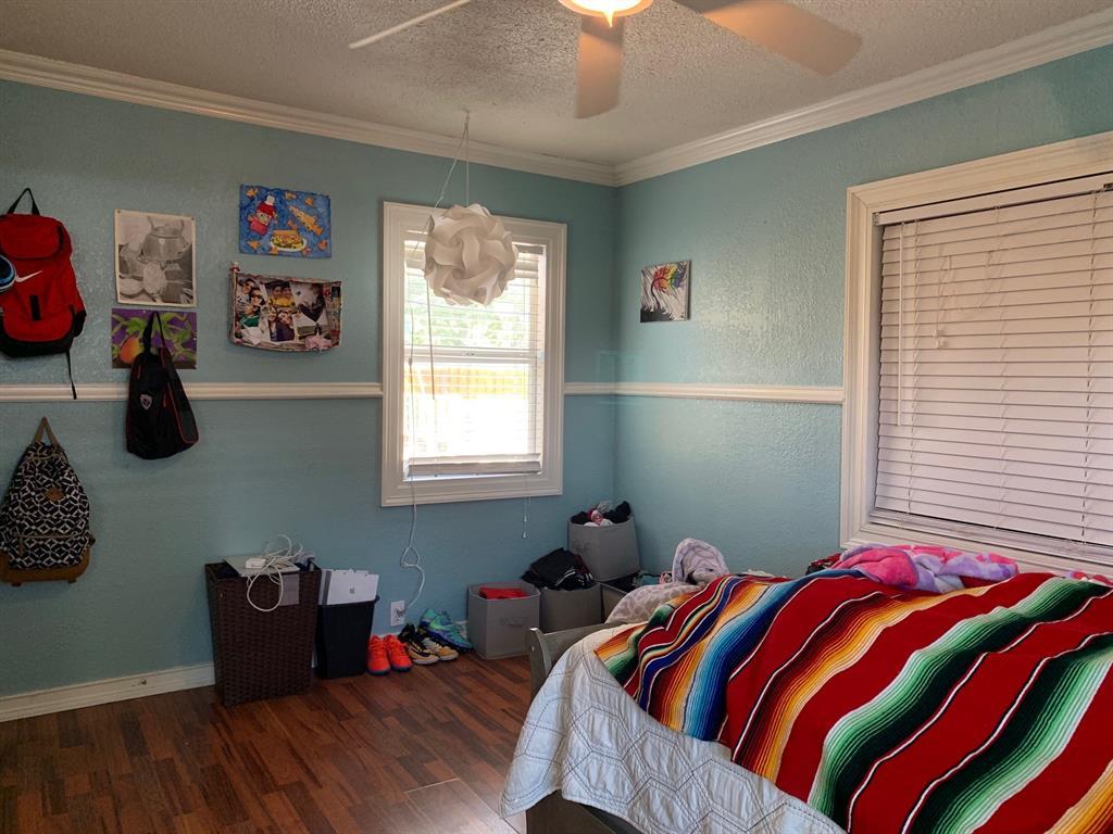 A bedroom with a bed and a ceiling fan