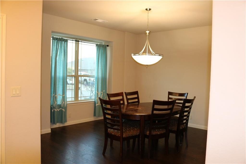 A dining room with a table and chairs and a chandelier