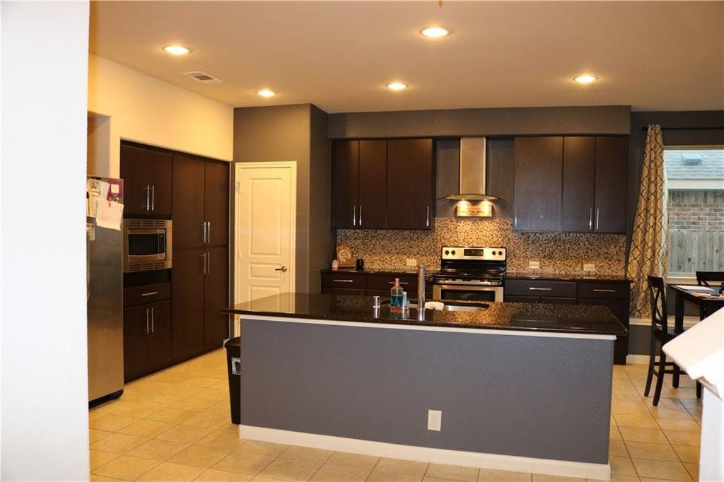 A kitchen with a large island and stainless steel appliances