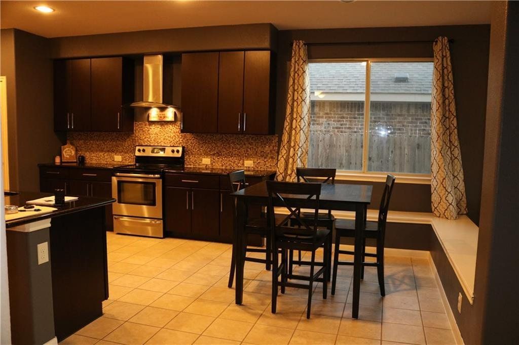 A kitchen with a table and chairs and a window.