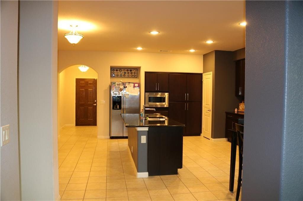 A kitchen with stainless steel appliances and a large island in the middle of the room.