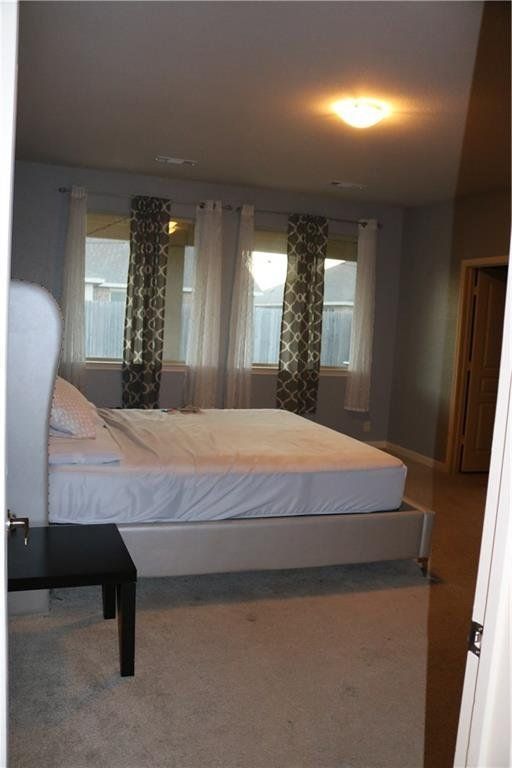 A bedroom with a large bed and two windows
