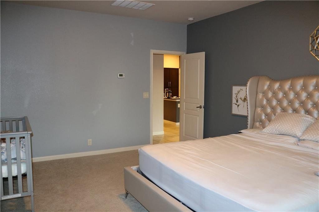 A bedroom with a large bed and a crib