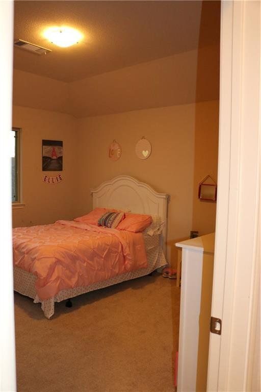 A bedroom with a white bed and pink sheets