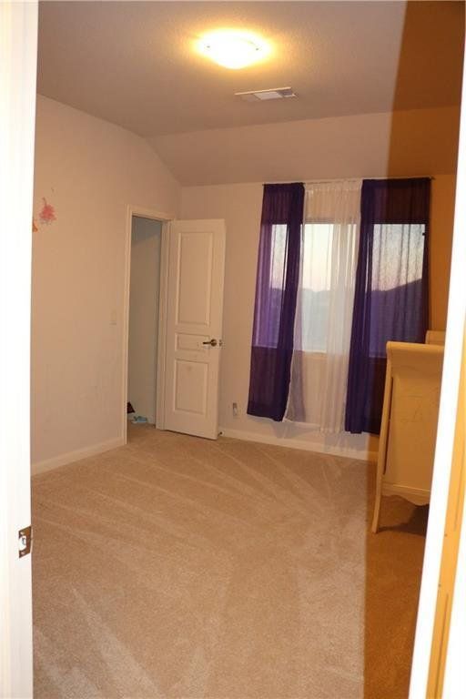 A bedroom with purple curtains and a white door