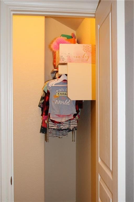 A closet filled with clothes and a shirt that says i love the world