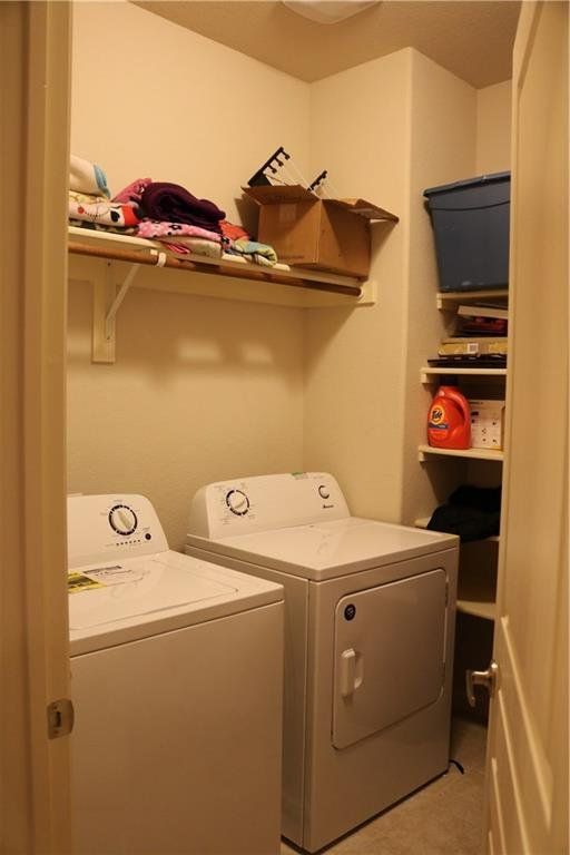 A laundry room with two washers and a dryer
