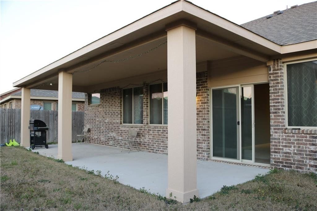 A brick house with a covered patio and sliding glass doors