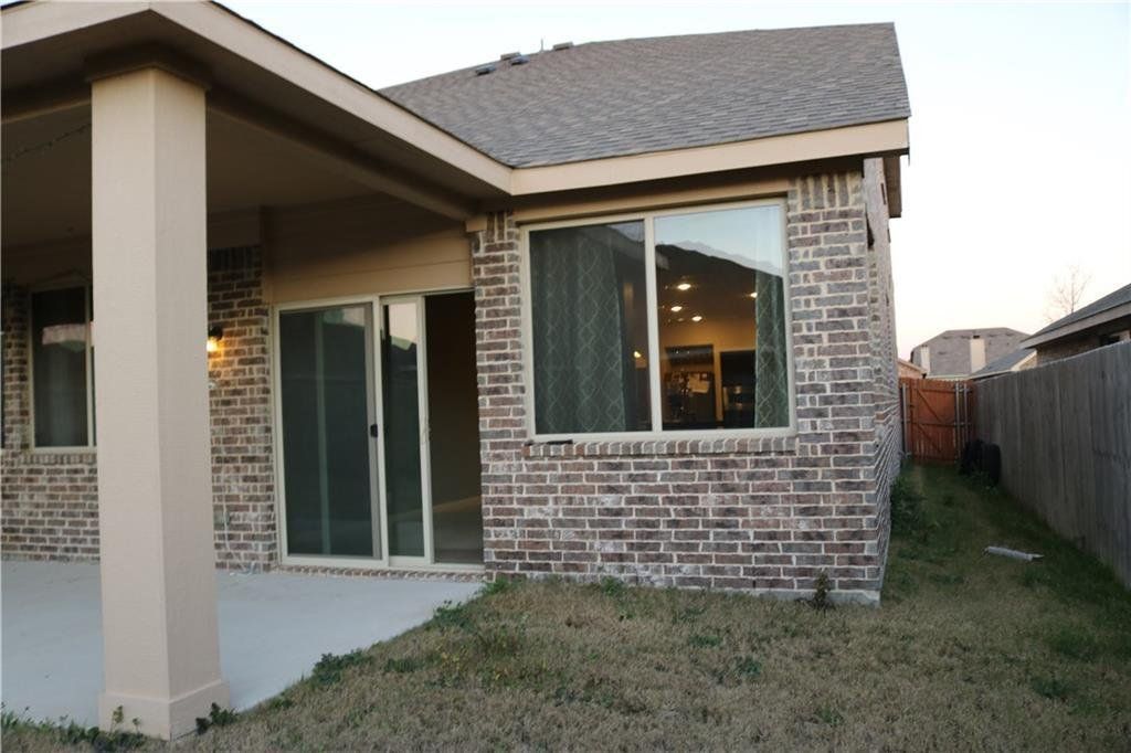 A brick house with a large window and sliding glass doors