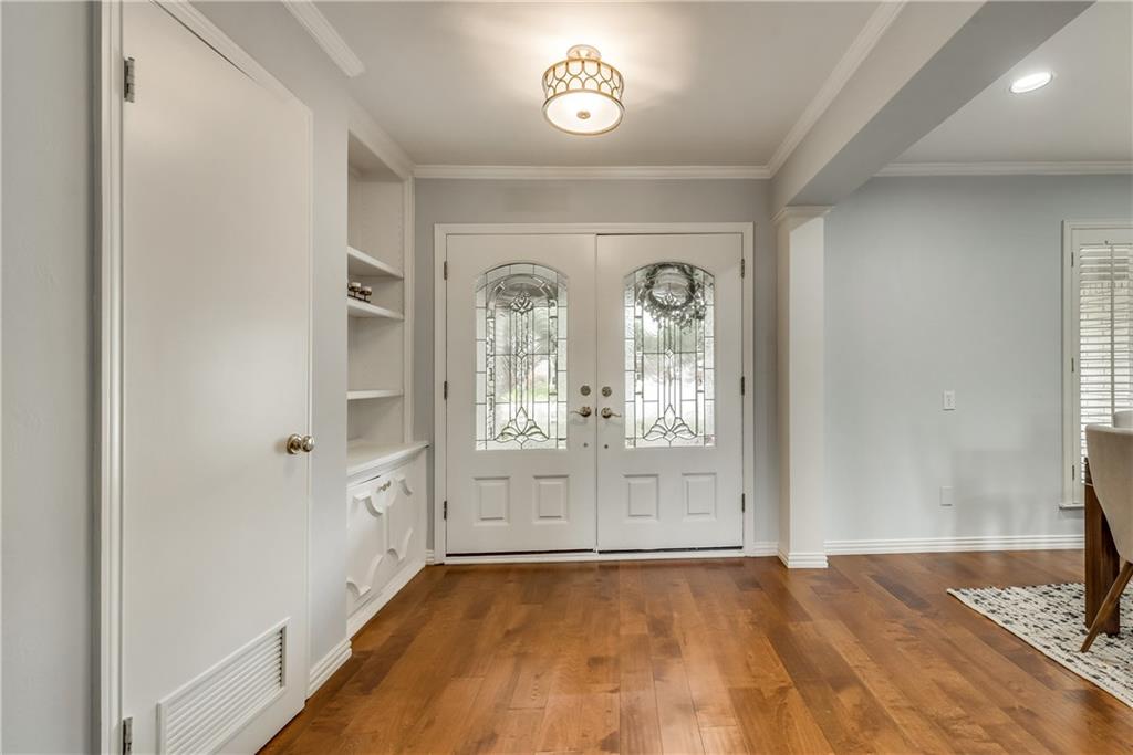 A hallway with hardwood floors and white doors