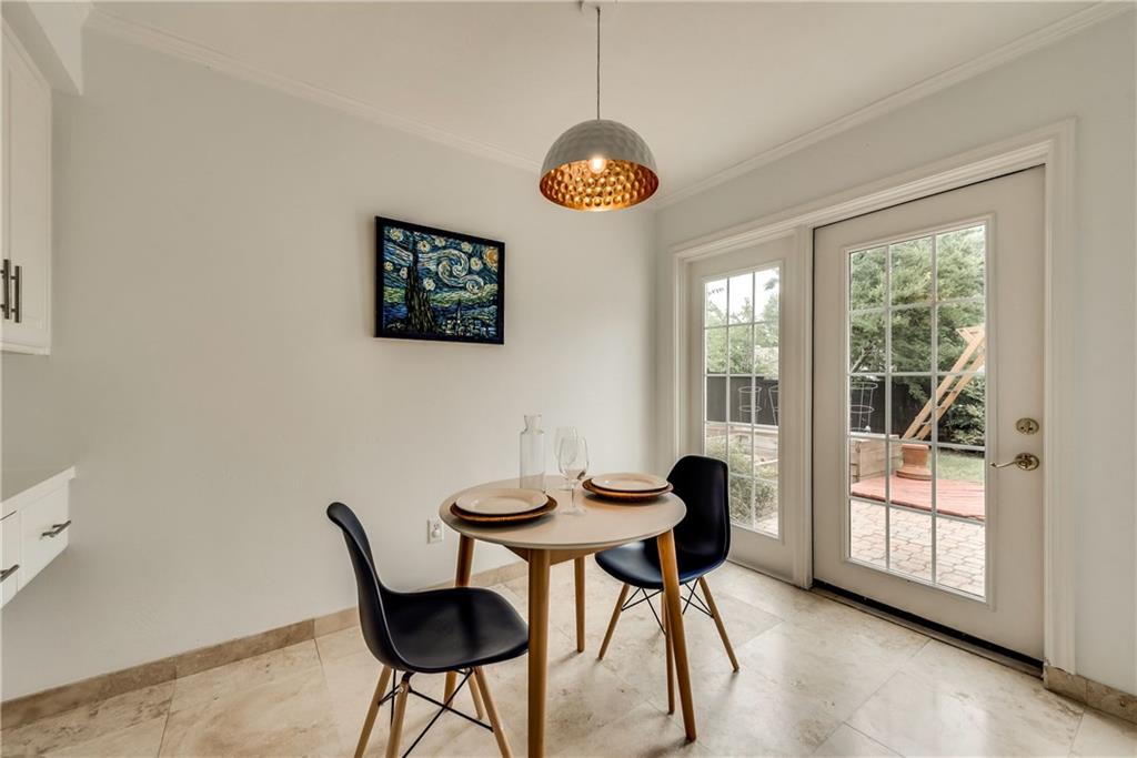 A dining room with a table and chairs and a sliding glass door.