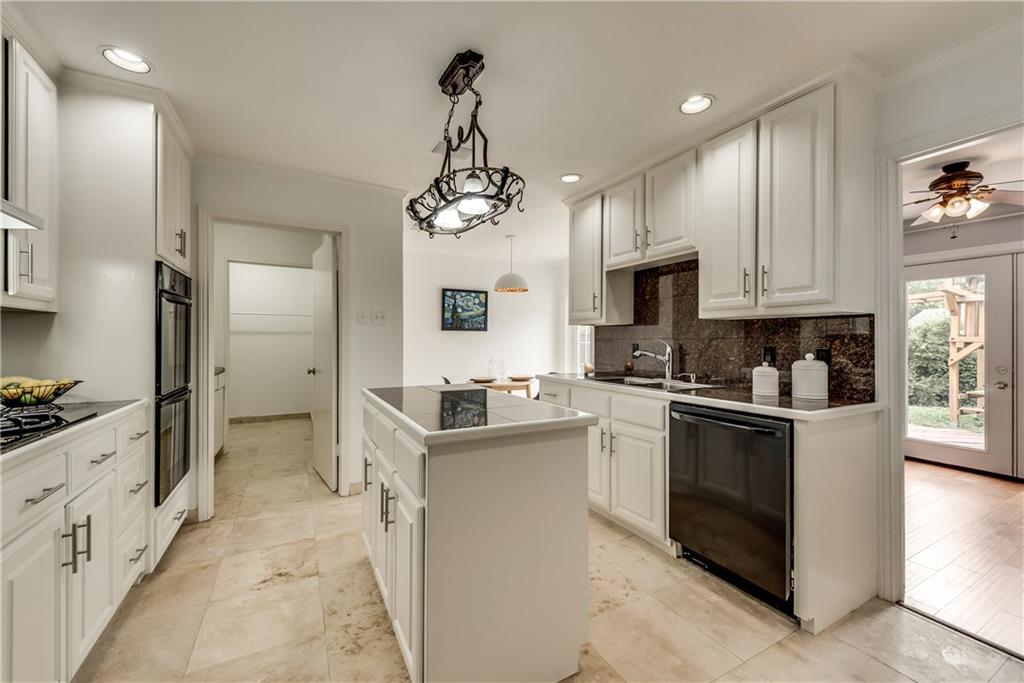 A kitchen with white cabinets and black appliances
