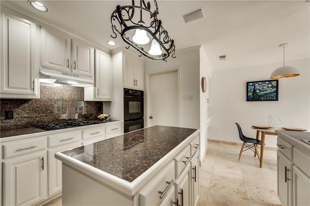 A kitchen with white cabinets and granite counter tops