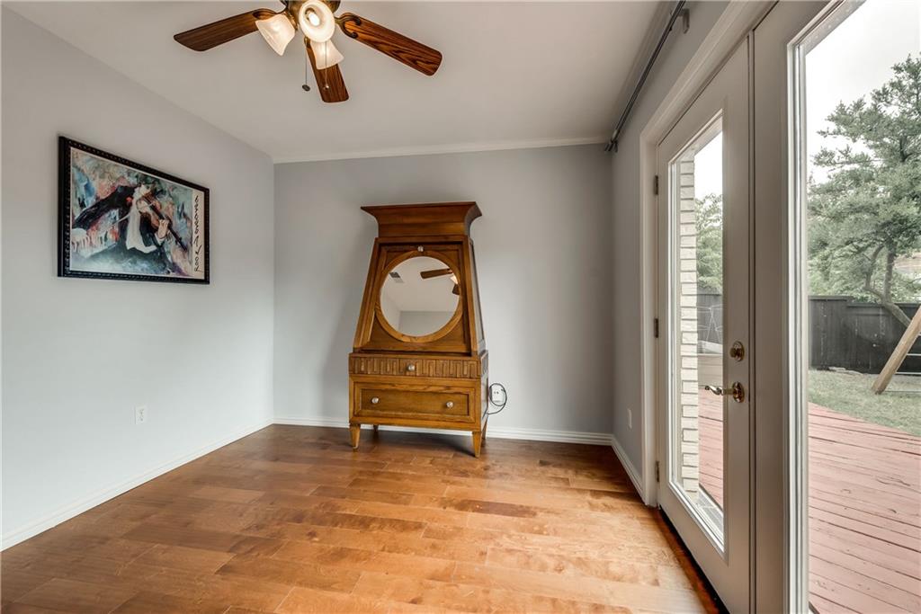 An empty room with hardwood floors and a ceiling fan
