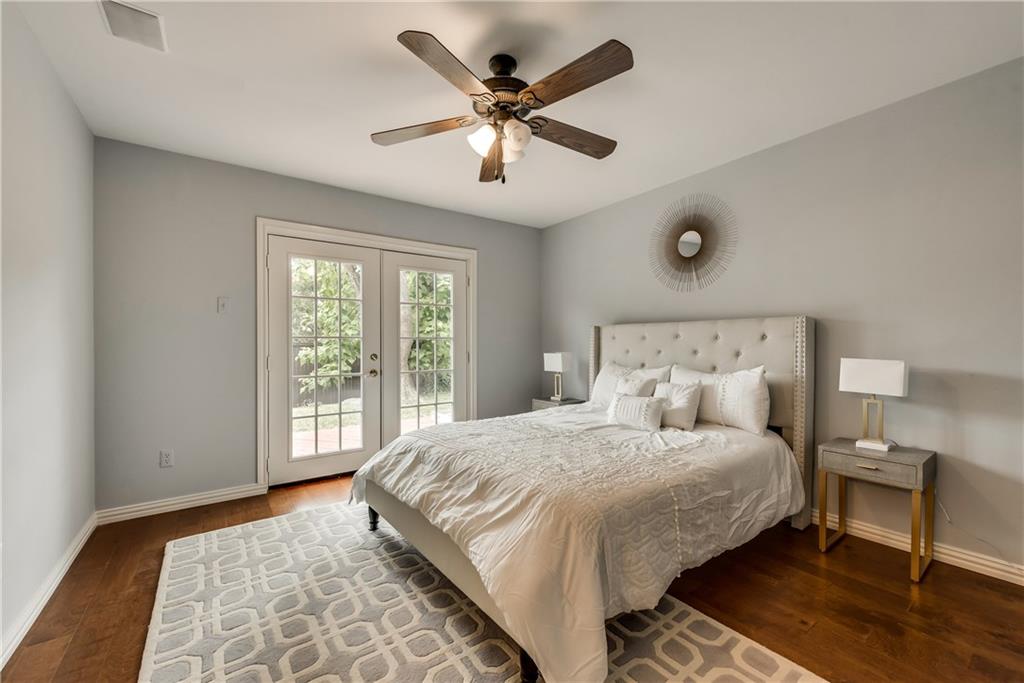 A bedroom with a large bed and a ceiling fan.