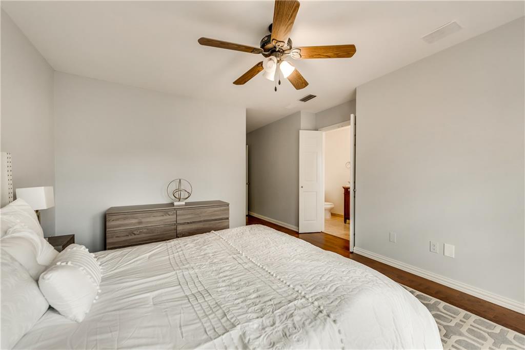 A bedroom with a large bed and a ceiling fan.
