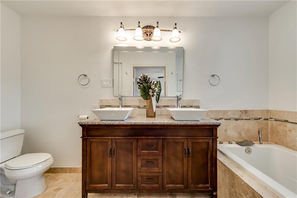 A bathroom with two sinks a toilet and a bathtub