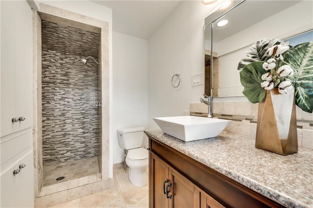 A bathroom with a sink , toilet , and walk in shower.