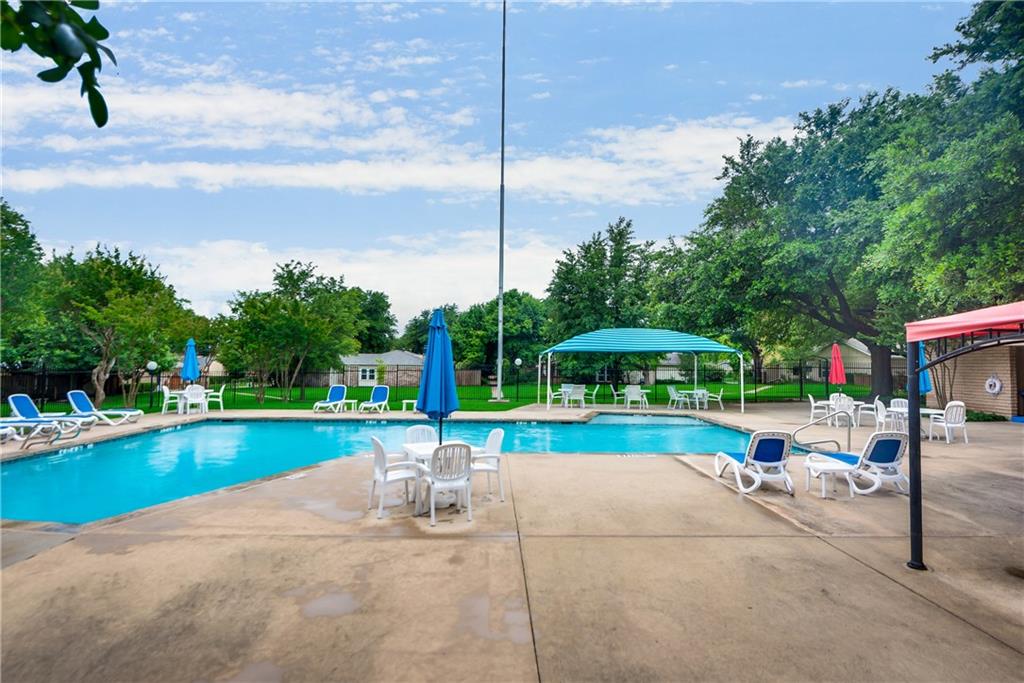 A large swimming pool surrounded by chairs and umbrellas