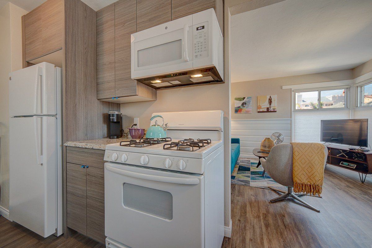 a kitchen with a stove , microwave and refrigerator .