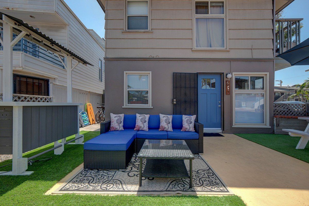 a house with a blue door and a blue couch in front of it .