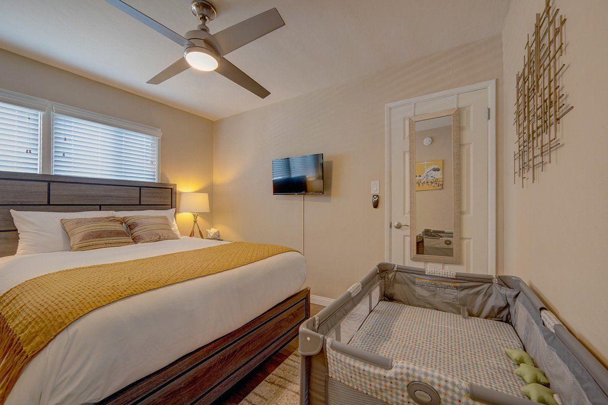 a bedroom with a king size bed and a crib .