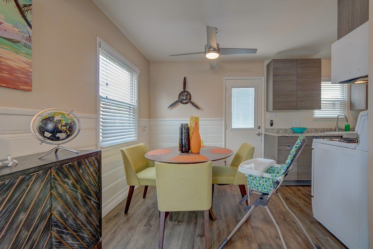 a dining room with a table and chairs and a high chair .