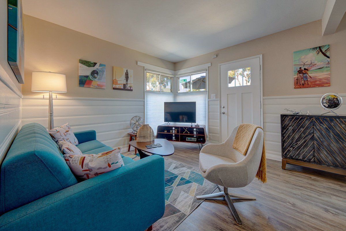 a living room with a blue couch and a white chair .