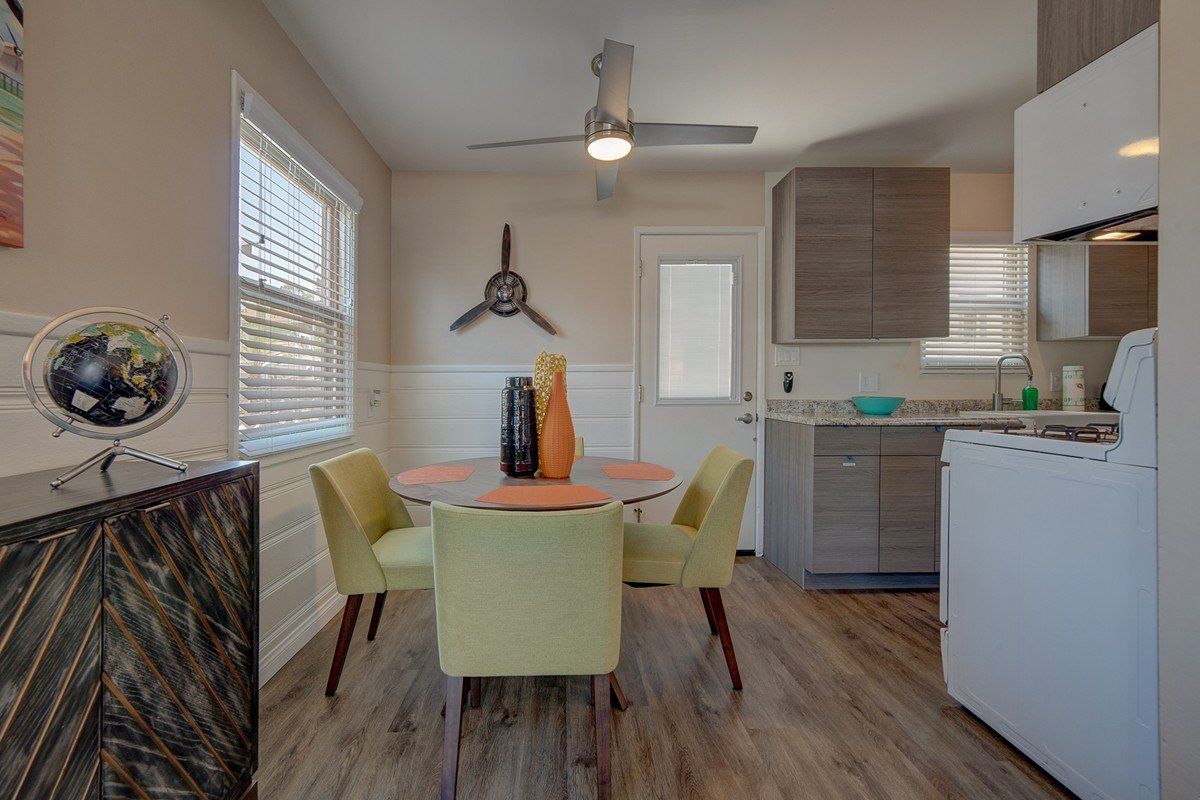 a dining room with a table and chairs and a ceiling fan .