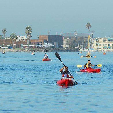 A man in a red kayak with a paddle in the water