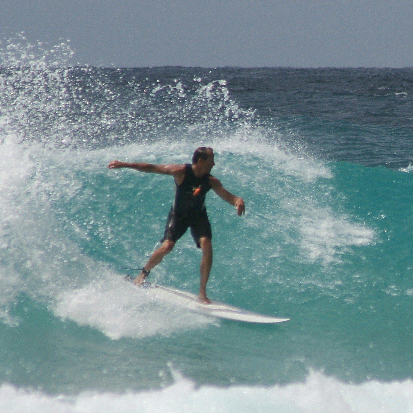 A man is riding a wave on a surfboard in the ocean