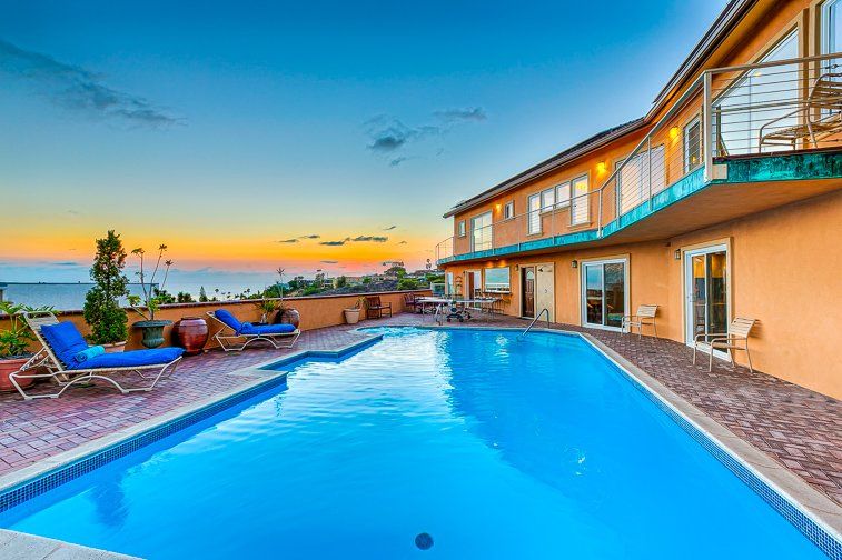 A large house with a swimming pool in front of it