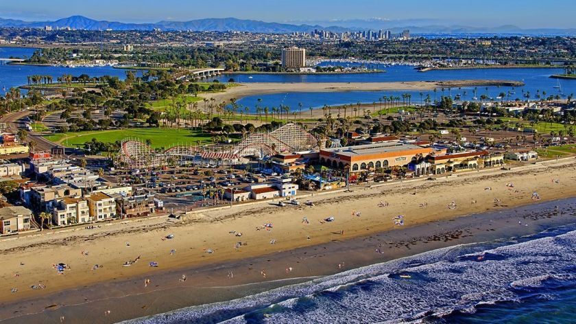 an aerial view of a beach with a city in the background .
