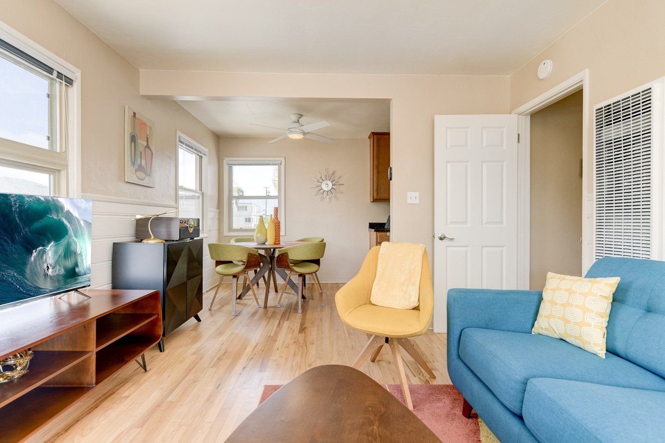 A living room with a blue couch and a yellow chair.