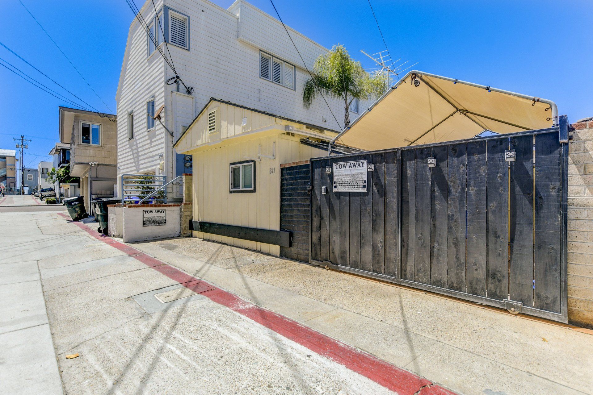 a building with a fence in front of it and a sidewalk in front of it .