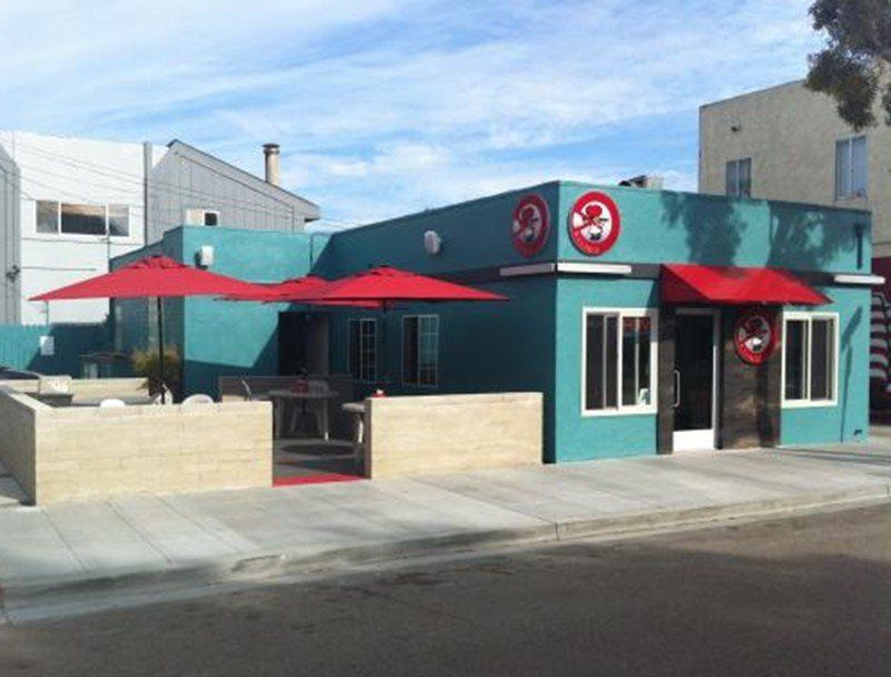 a blue building with red umbrellas in front of it