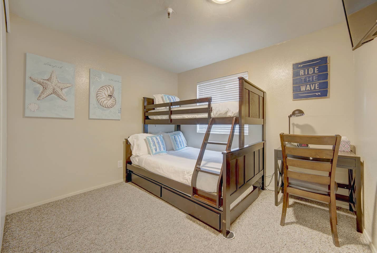 A bedroom with a bunk bed and a desk.