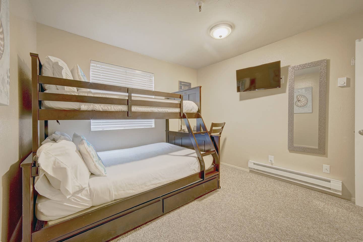 A bedroom with a bunk bed and a desk.