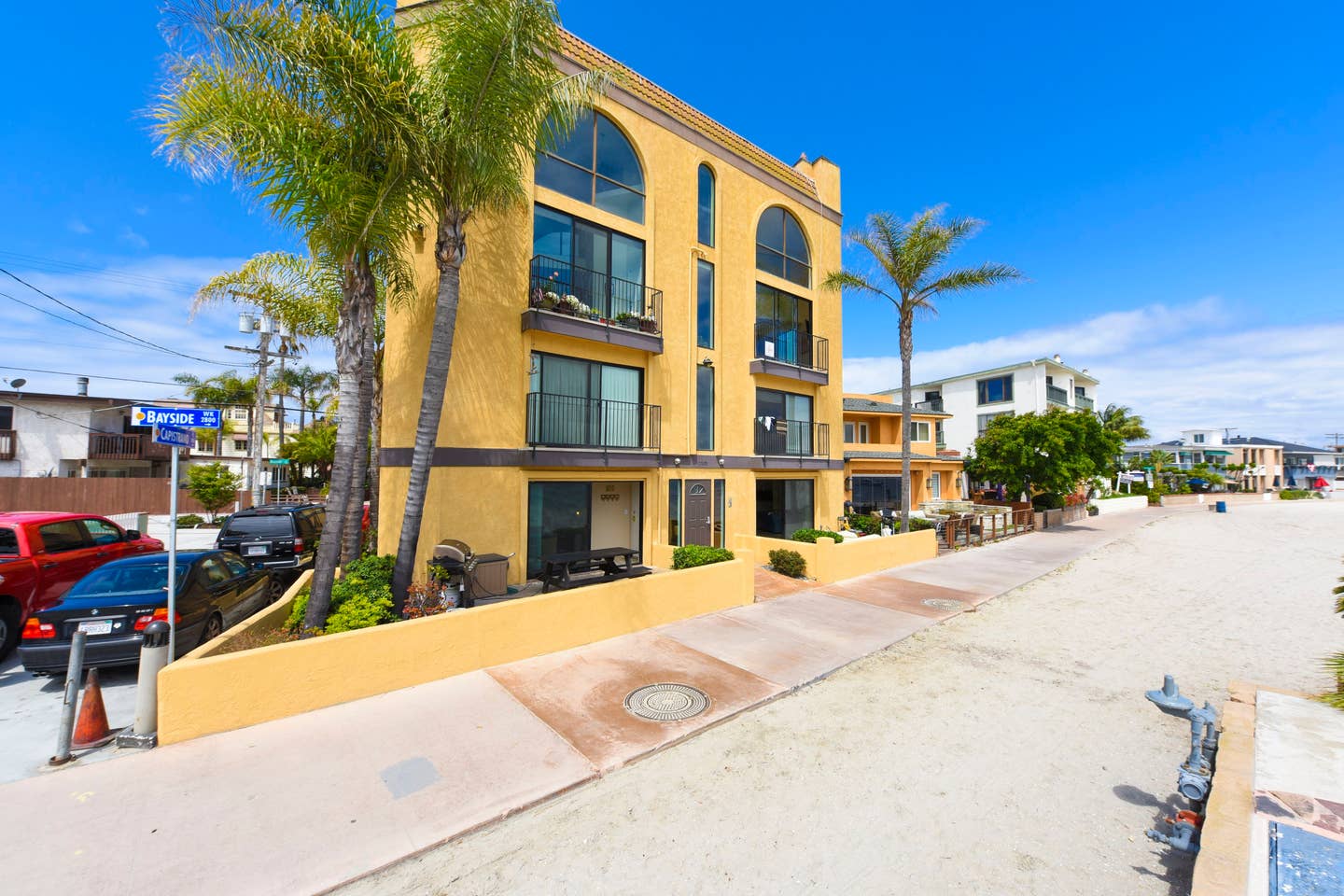 A large yellow building with palm trees in front of it