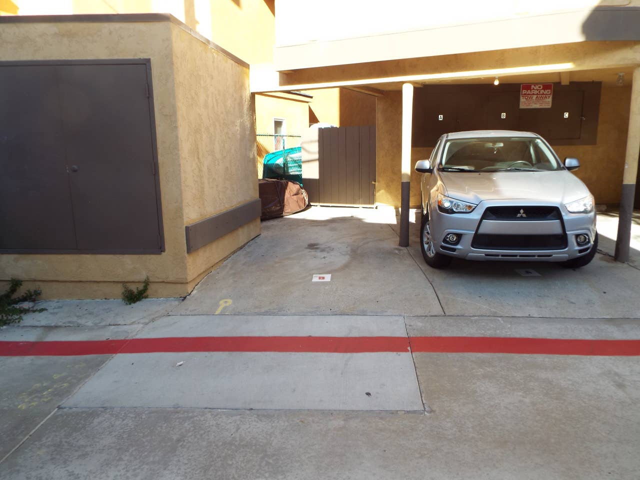 A silver car is parked in front of a building