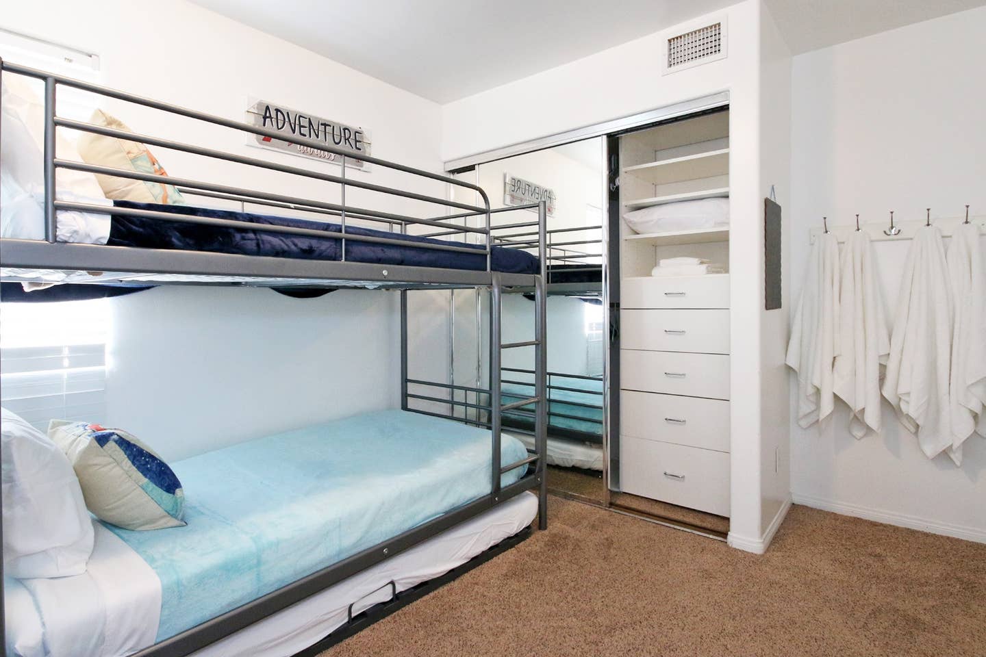 A bedroom with bunk beds and a sign that says adventure