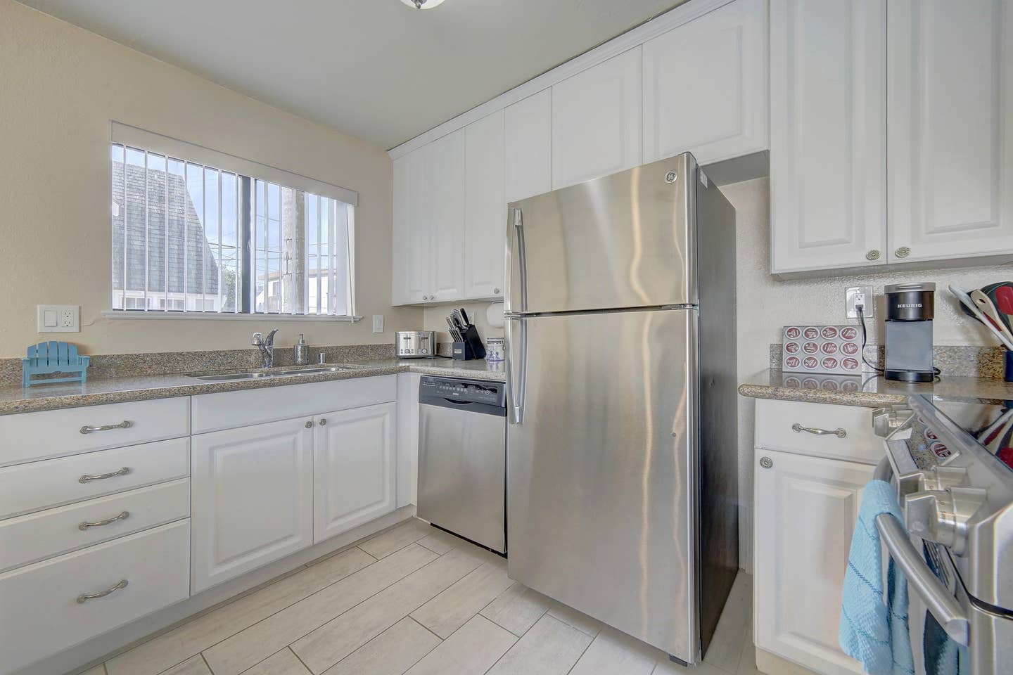 A kitchen with stainless steel appliances and white cabinets.