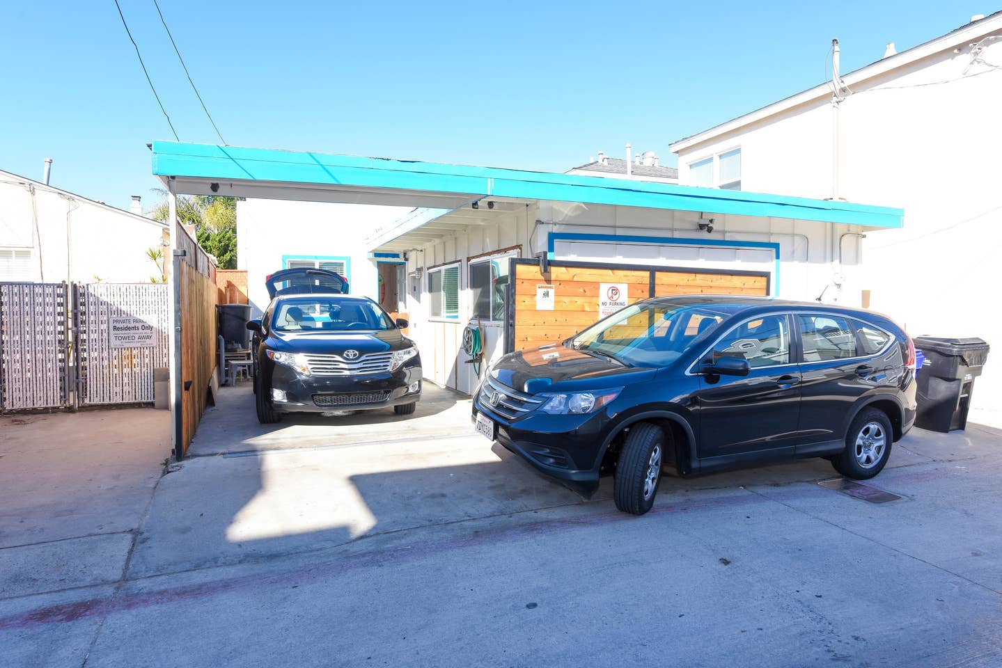 Two cars are parked in front of a building.
