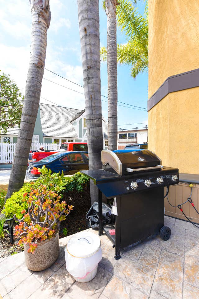 A grill is sitting on a patio next to a building.