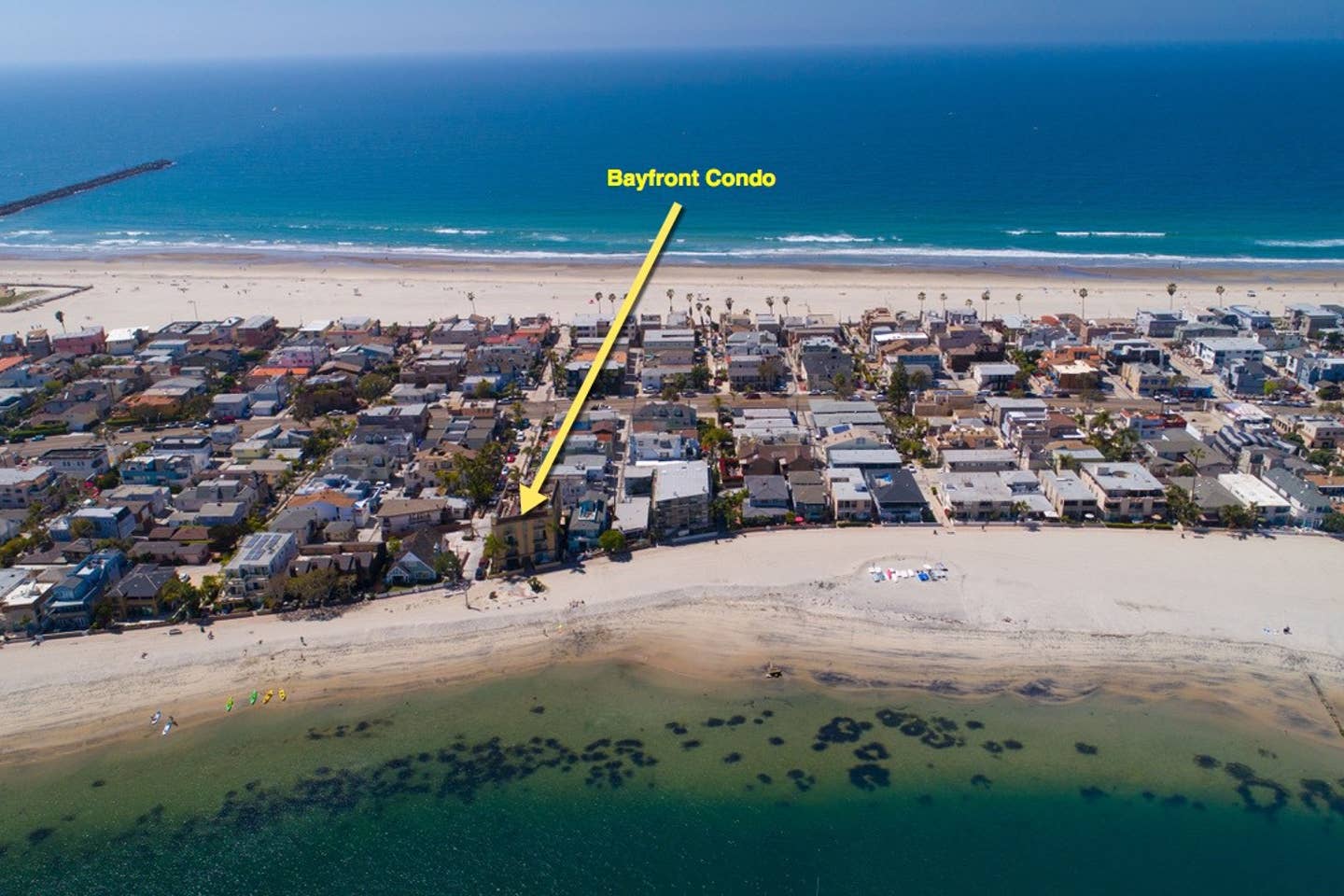 An aerial view of a beach with a yellow arrow pointing to the bayview condo