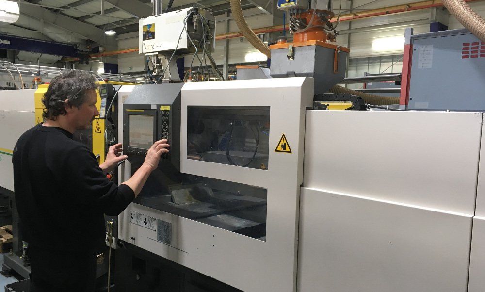 Ein Mann arbeitet in einer Fabrik an einer Maschine.