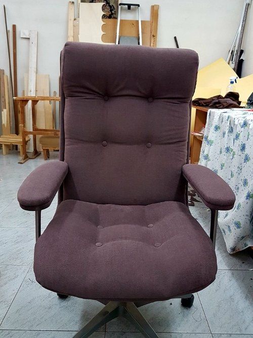 una poltrona di ufficio rivestita in una stoffa di color viola