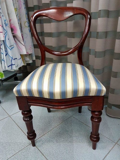 una sedia con un cuscino rivestita con una stoffa a righe