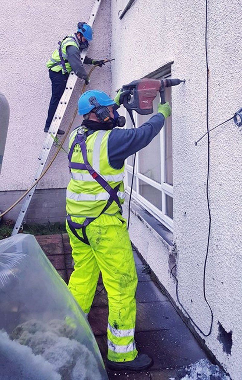 workers removing cavity wall installation